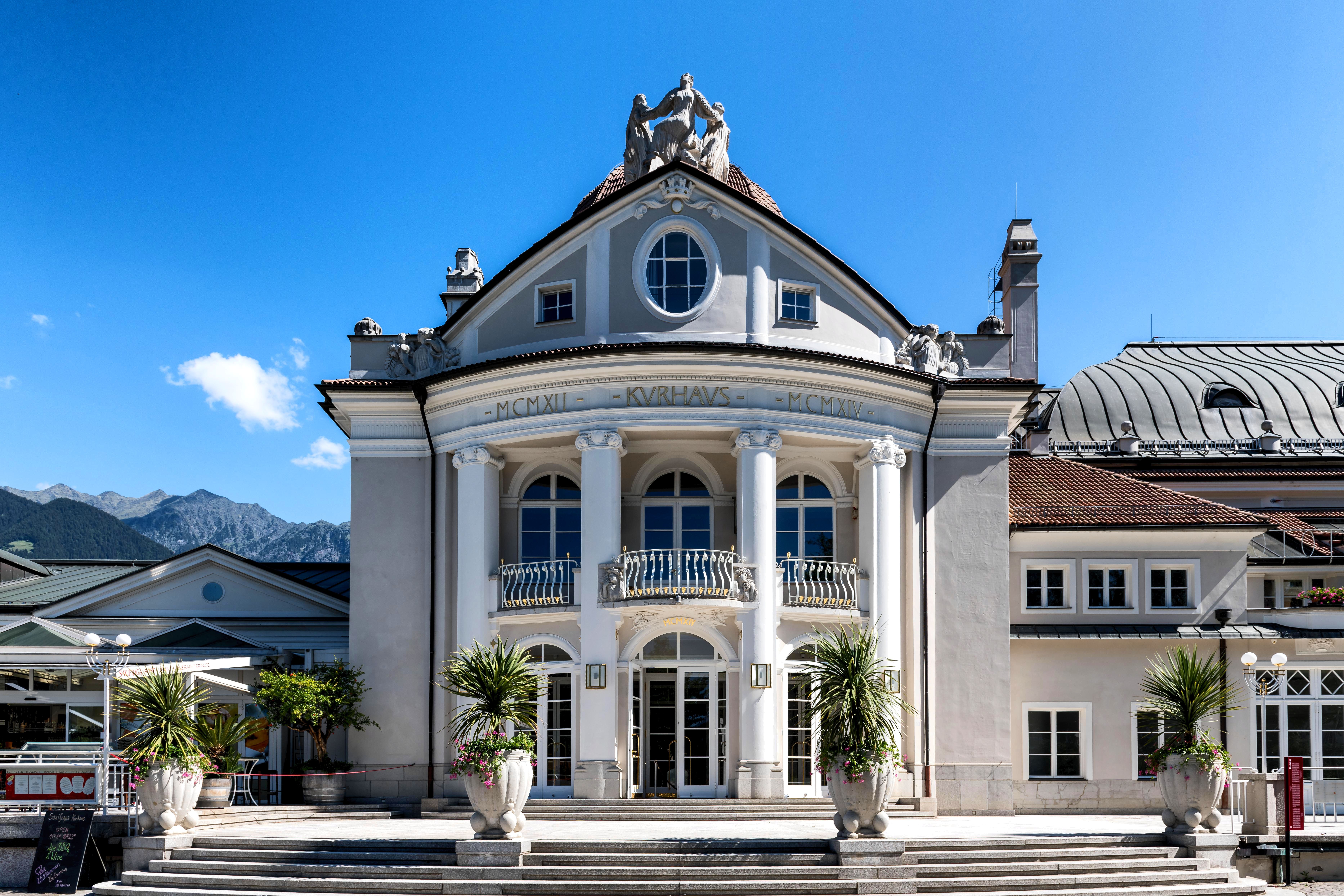 The curved facade, columns and roof sculptures of the Kurhaus in Merano